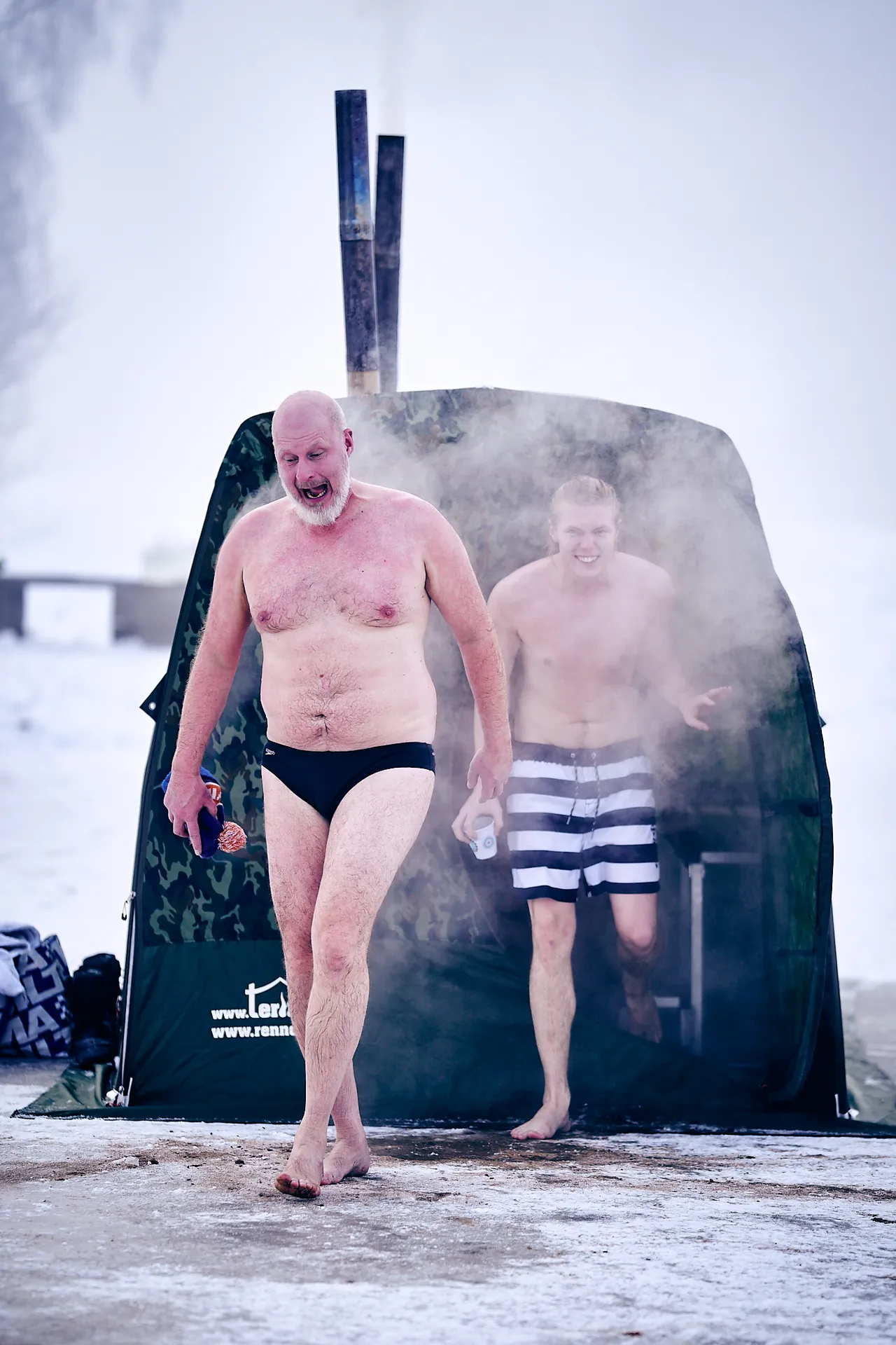 Ånga väller ut ur bastutältet när gästerna kliver ut i snön